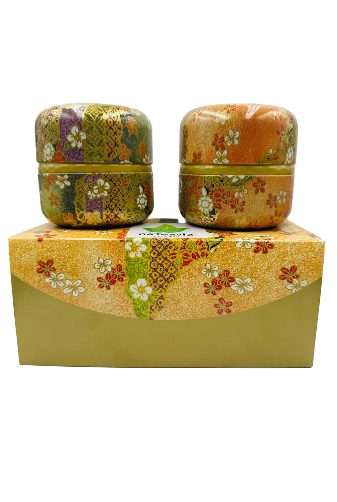 Two decorative tea canisters with floral patterns on a matching box against a white background.